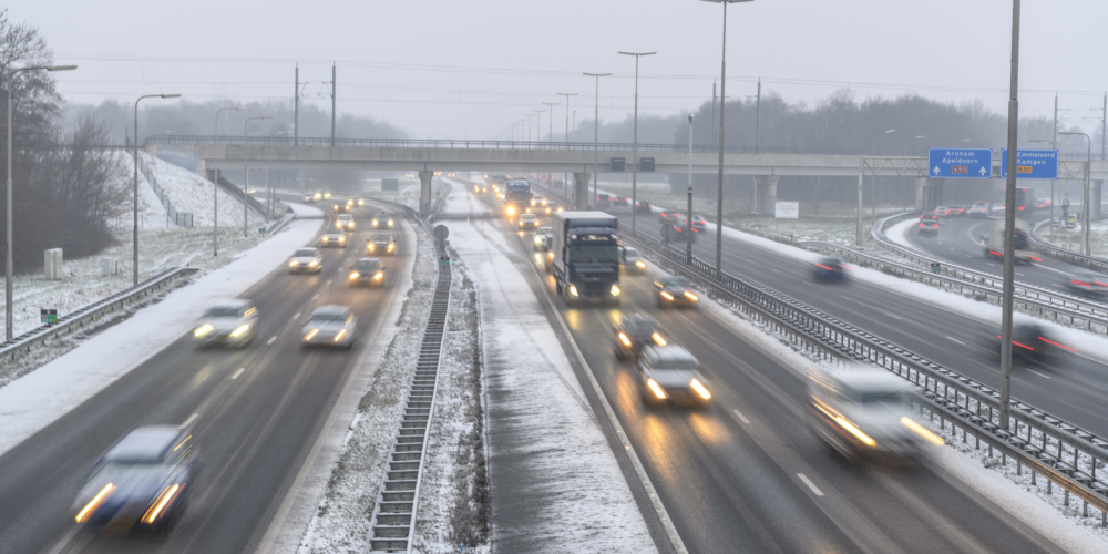 Moving traffic on a highway during a snow blizzard in winter