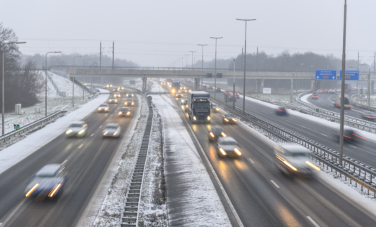 Moving traffic on a highway during a snow blizzard in winter