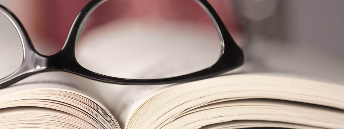 Glasses are laying on a book