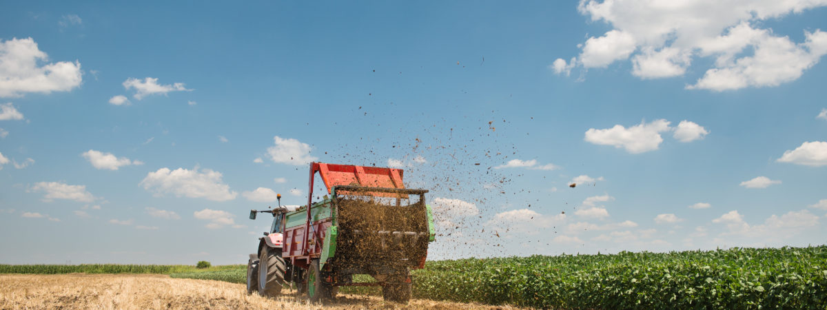 A tractor spreading manure on a field