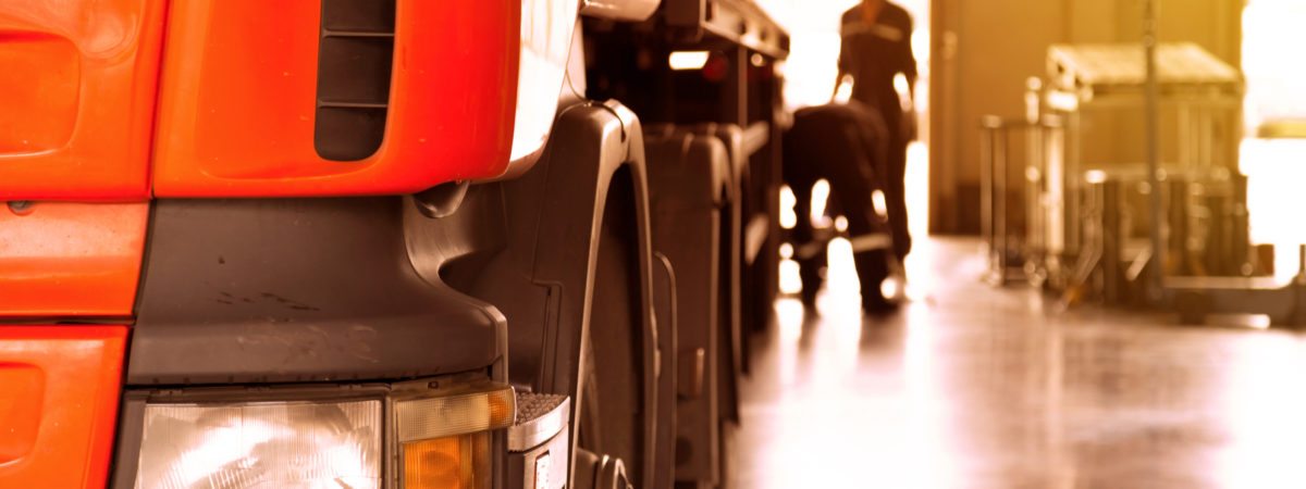 automobile mechanic checking truck in the garage with sunbeam, selective focus